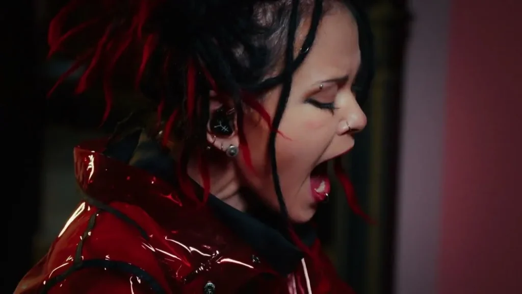 Dariya Stavrovich with red and black dreadlocks singing, a close-up in profile