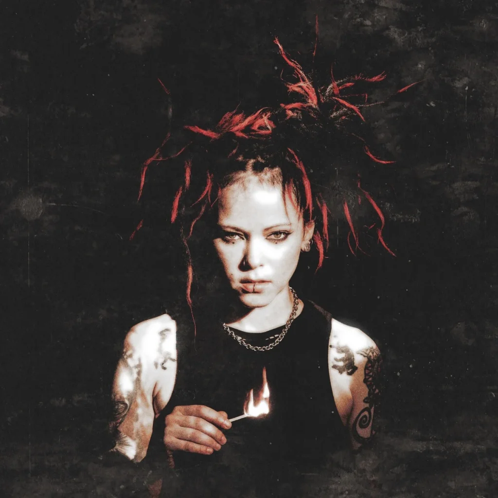Dariya Stavrovich with red dreadlocks holding a lit match