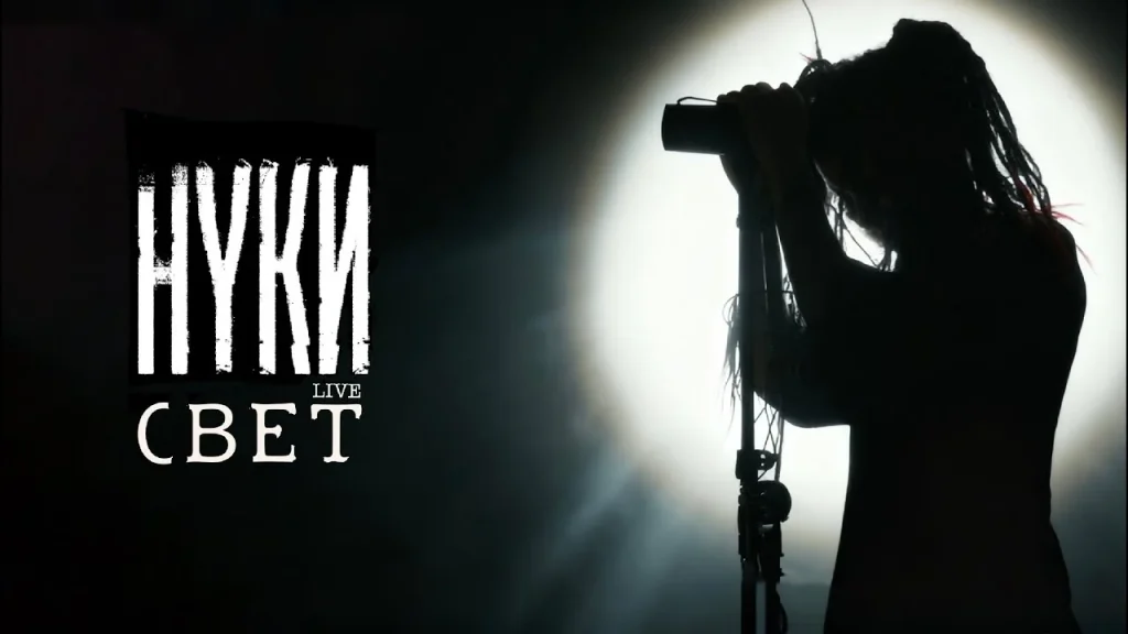 Dariya Stavrovich’s silhouette at a microphone stand against a spotlight, with the words “Nuki live Svet”