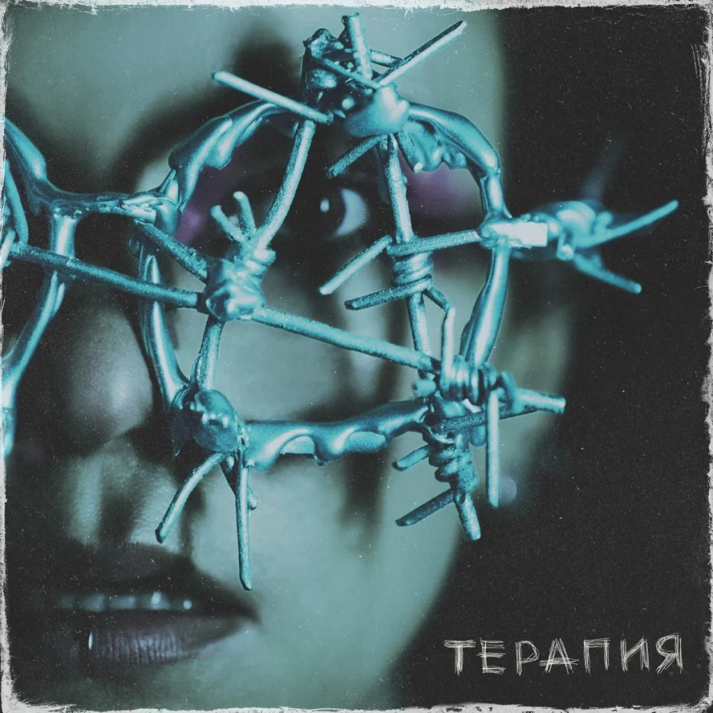 A face behind a mask of barbed wire, with the word “Terapiya”